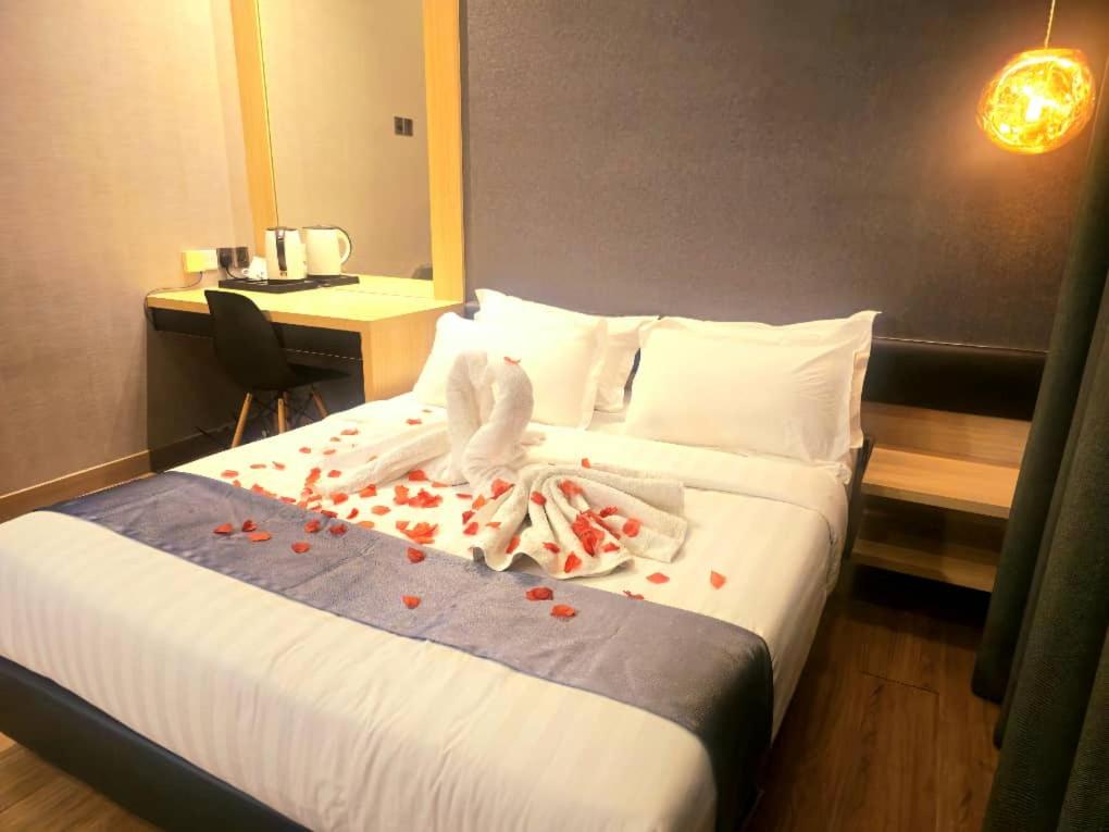 a hotel room with a bed with rose petals on it at Landmark Residence 1 And 2 - Kajang in Kajang