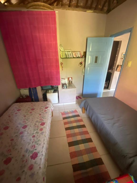 a bedroom with two beds and a mirror at Casa de Praia Descanso das Trilhas in Angra dos Reis