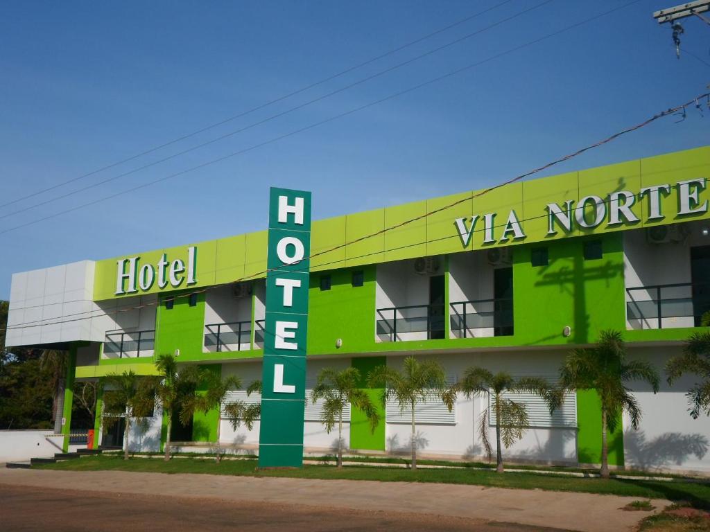 a hotel with a green building with a hotel sign at Via Norte Hotel in Gurupi