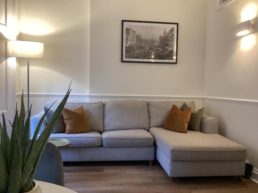 a living room with a couch and a picture on the wall at Ladbroke Grove Station -Stunning, Stylish Brand new apartment in London