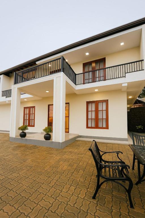 a house with two benches in front of it at Bloomingdale Bungalows - Nuwaraeliya in Sita Eliya