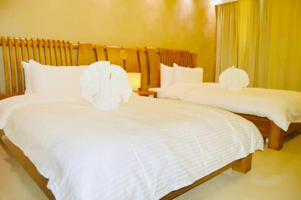 Yara Suites في بريدة: غرفة نوم بها سريرين مع ملاءات بيضاء