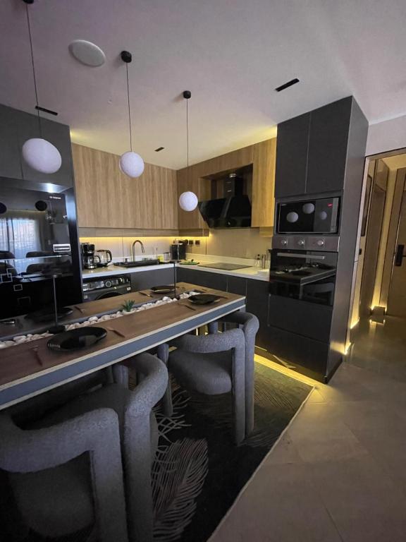 a kitchen with a large island with bar stools at اكوا فيو الساحل الشمالي in El Alamein