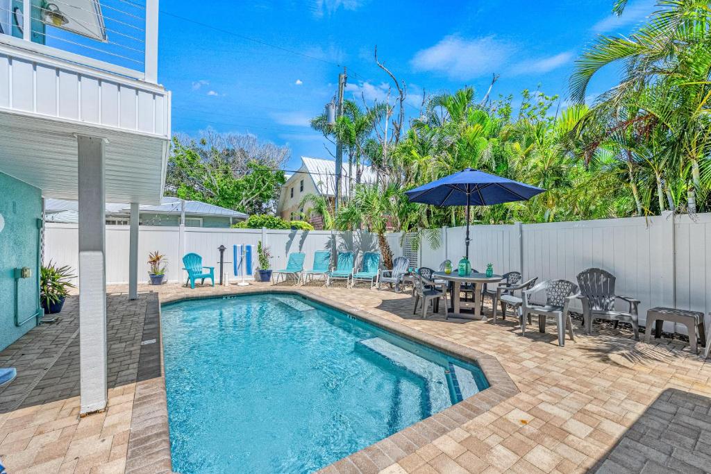 a swimming pool with a table and chairs and an umbrella at Lantana - 5251A in Siesta Key