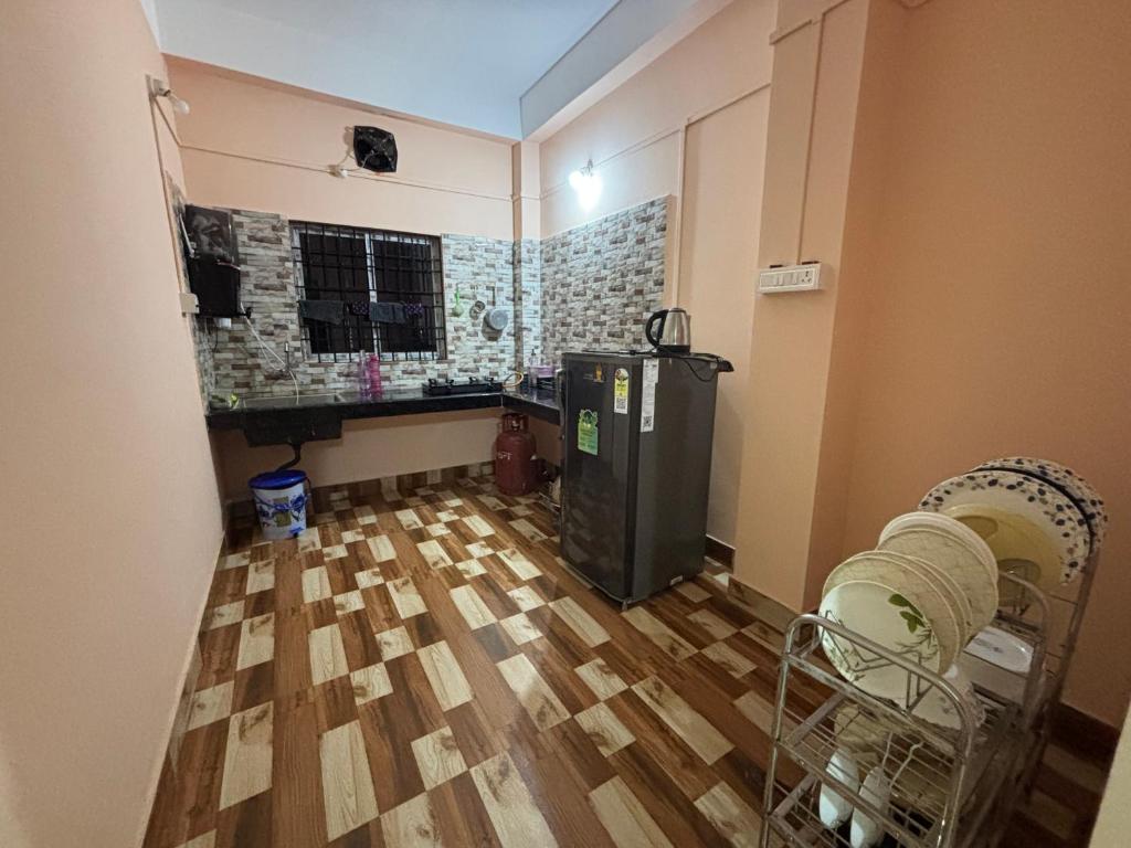a room with a refrigerator and a hard wood floor at Aalohee Homestay in Guwahati