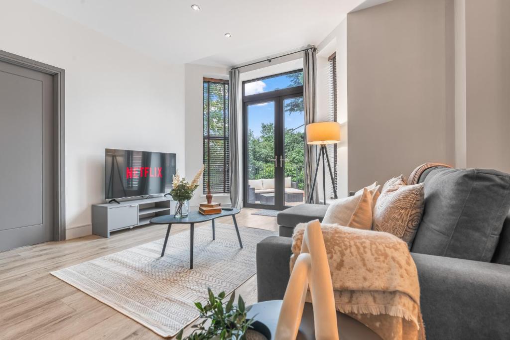 sala de estar con sofá gris y TV en Luxury 2 Bed Terraced Apartment In Slough, en Slough