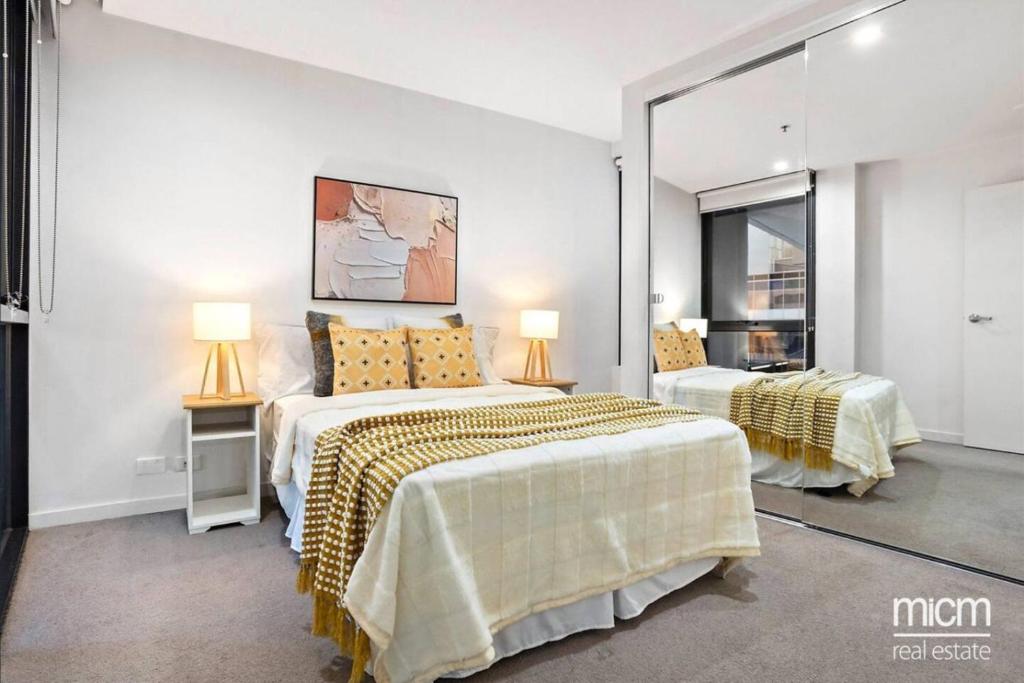 a bedroom with two beds and two lamps in it at Serrata - 2B2B Docklands Apt Parking Available in Melbourne