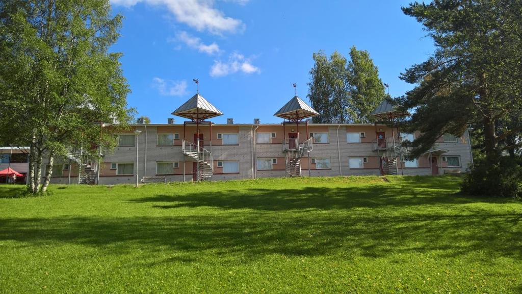 un edificio con un gran campo de césped delante de él en Huoneistohotelli DomusVirrat, en Virrat