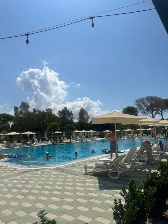 a pool with chairs and people in the water at Villa Amalia Perla Resort in Draçi