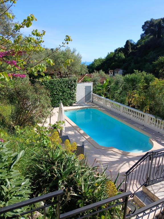 une piscine dans un jardin avec une clôture dans l'établissement Rez de villa avec piscine, à Menton