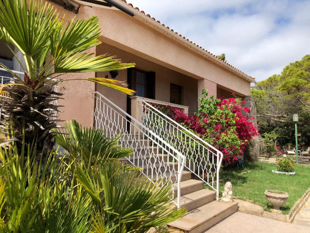 a house with stairs and flowers in the yard at VILLA route des sanguinaires in Ajaccio