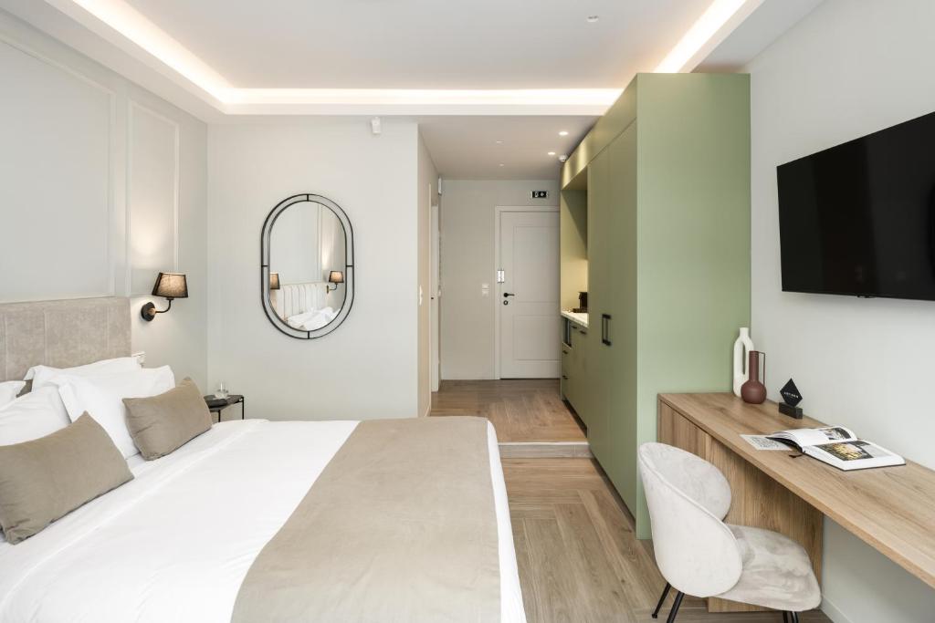 une chambre avec un grand lit blanc et un miroir dans l'établissement ASTIKON Xenofontos Suites, à Athènes