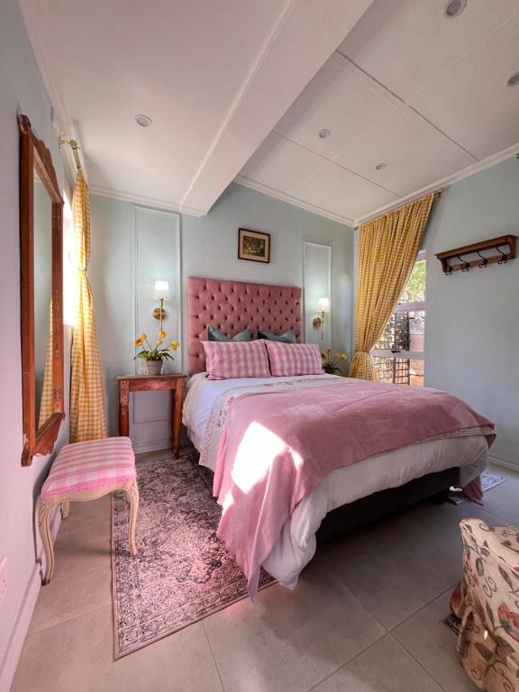 a bedroom with a pink bed with a pink headboard at Cosy Cottage Greenside in Johannesburg