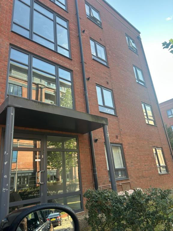 a side view mirror of a red brick building at Lovely 1 bedroom top floor flat at Chocolate Quarter near city of Bath in Keynsham