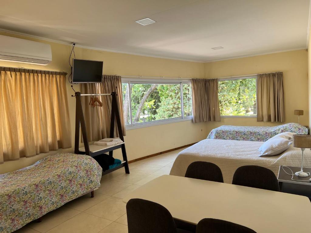 a hotel room with two beds and a television at Las Margaritas in Pila