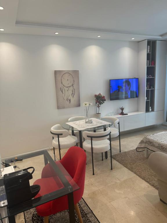 salon z czerwonym krzesłem i stołem w obiekcie Appartement moderne à Bourgogne 2 chambre w mieście Casablanca-Port