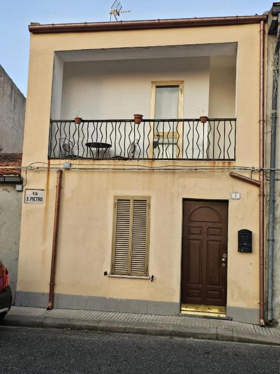 a building with a balcony and a door at angelhouse1 in Pozzomaggiore