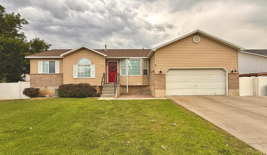 a house with a red door and a garage at Lovely Provo Oasis in Provo
