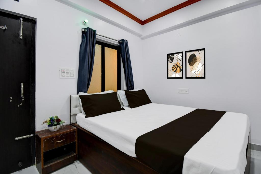 a bedroom with a bed with white sheets and a window at Hotel O Moon Light in Patna