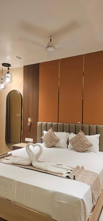 a bedroom with a large bed with two swans on it at Hotel Vaishno Regal in Bhubaneshwar