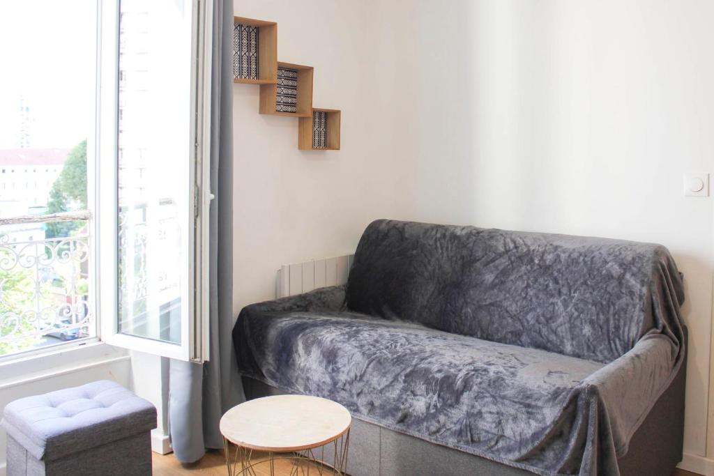 un salon avec un canapé et une table dans l'établissement Attractive fully-equipped apartment near Paris, à Aubervilliers