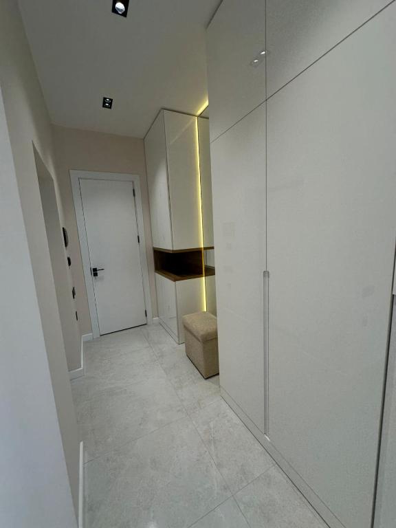 a white hallway with a door and a room with a door at Квартира в SEEBREZE in Nardaran
