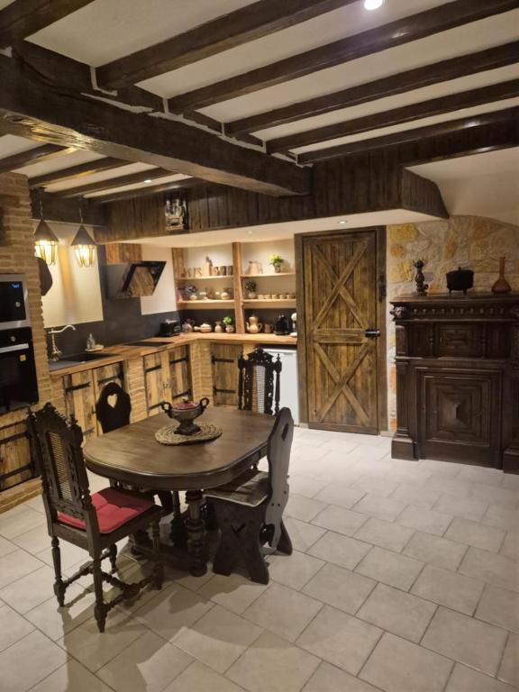 a large kitchen with a wooden table and a door at Maison Médiévale LAON in Laon