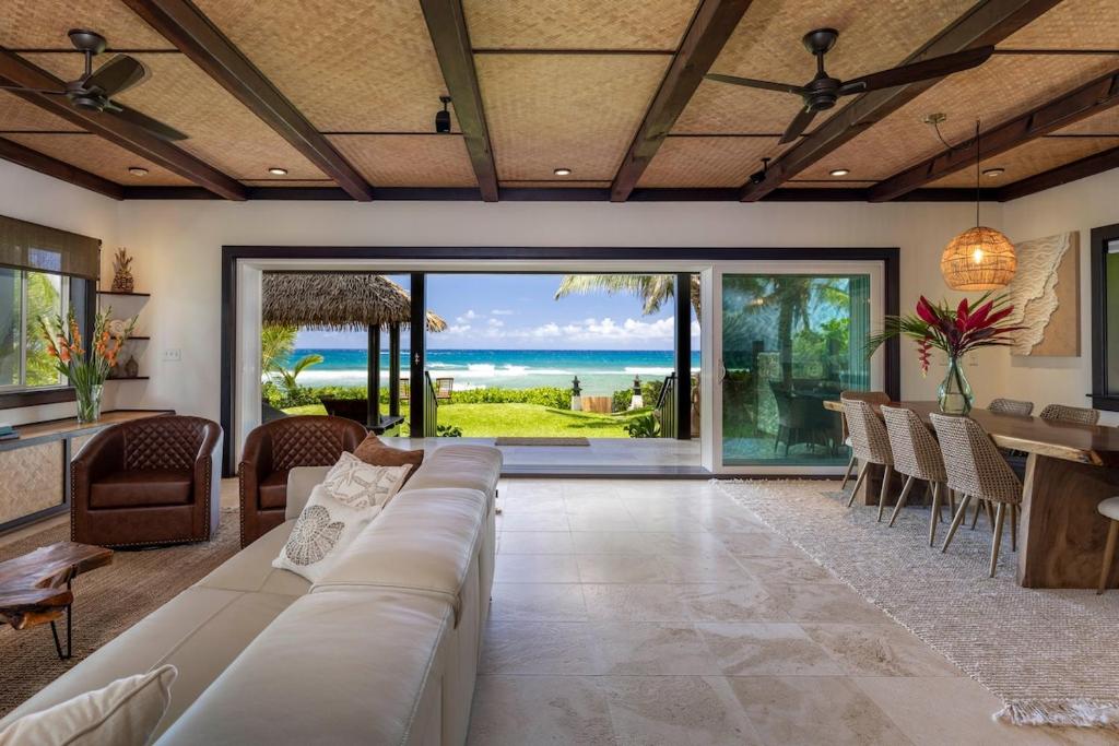 a living room with a couch and a table with a view of the ocean at Hale Holawa Mana-Oceanfront Sunset Beach in Haleiwa