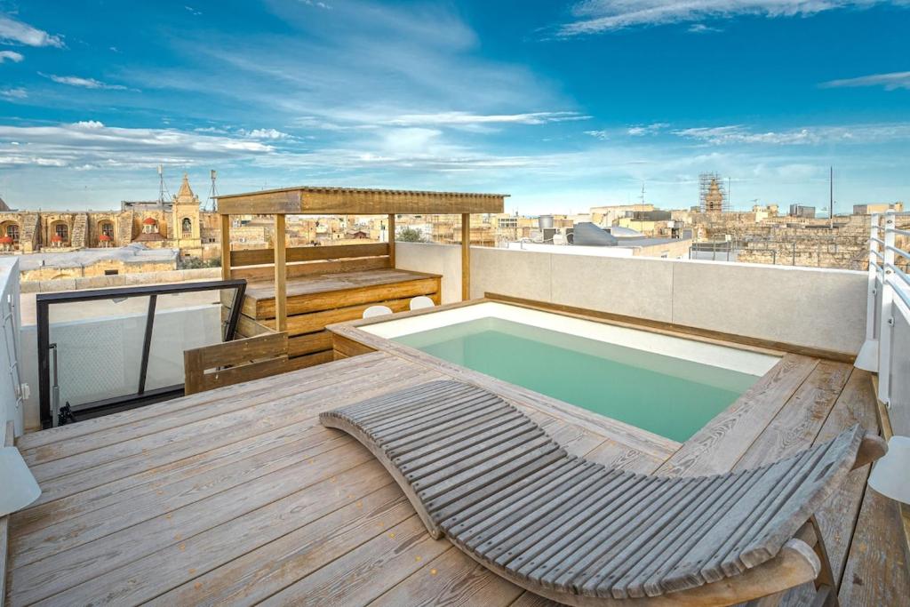 a balcony with a swimming pool on a roof at Modern Oasis Near Mdina with Rooftop Pool & View in Rabat