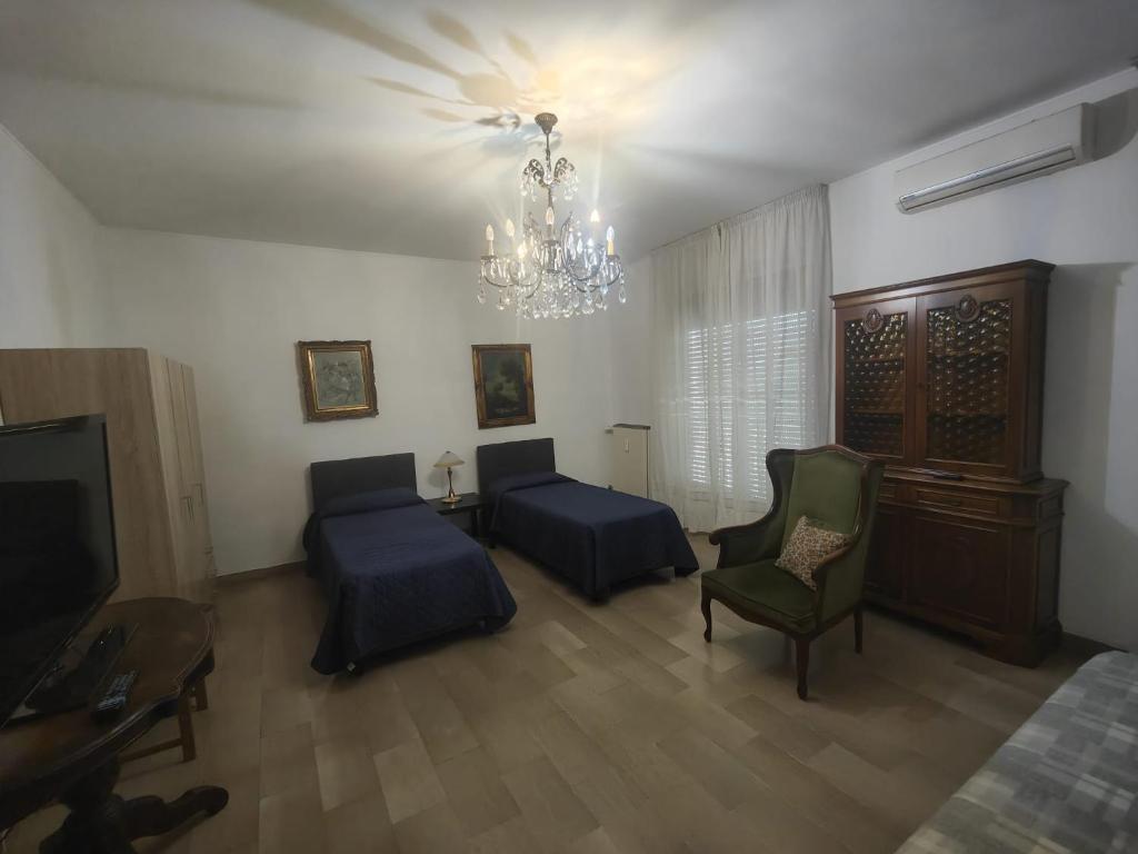 Antonelli apartments في نوفارا: غرفة معيشة مع أريكة وثريا