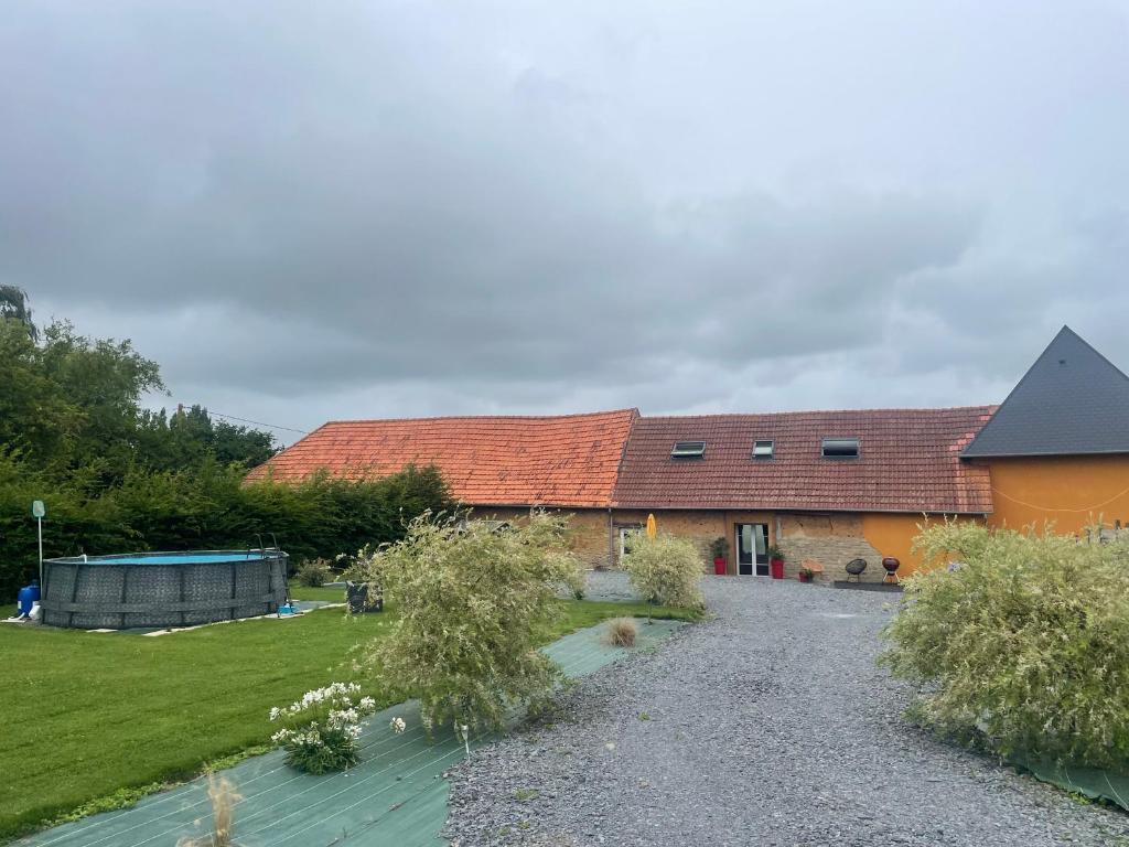 une maison avec une allée en gravier à côté d'une cour dans l'établissement Au cœur du marais,Le léonin, à Saint-André-de-Bohon