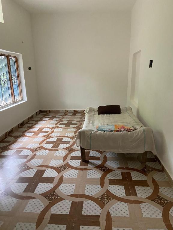 a room with a bed in the corner of a room at Himanshu in Jalālpur Dhai