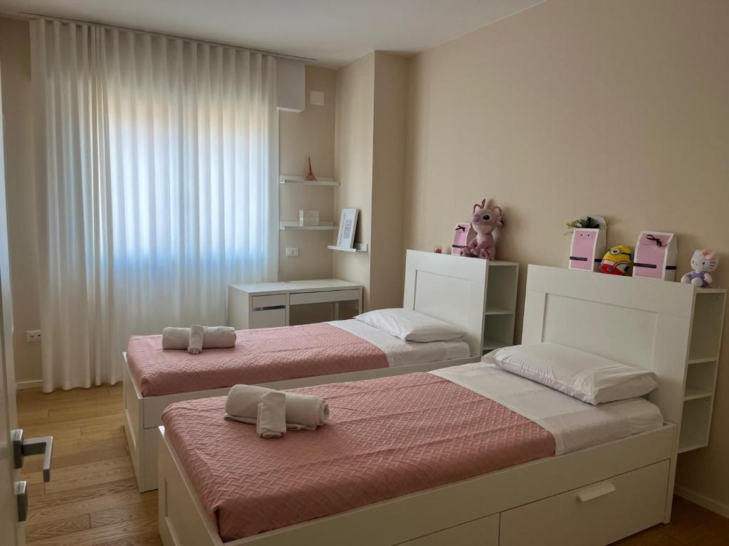 1 dormitorio con 2 camas con sábanas rosas en Ilary Home, en Venecia
