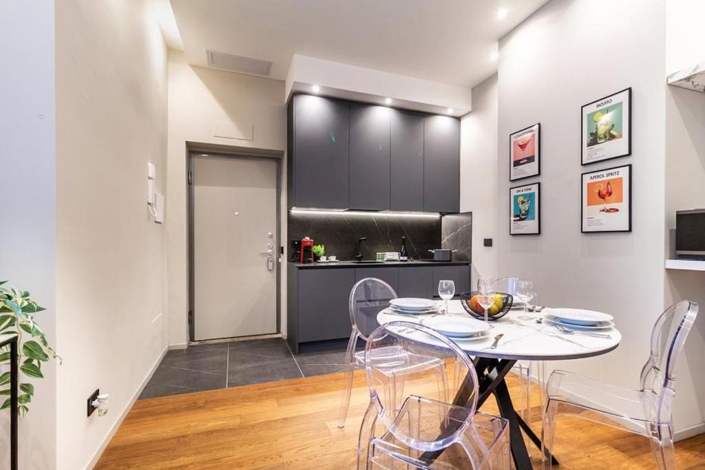 a dining room with a table and chairs and a kitchen at luxury house - como lake in Como