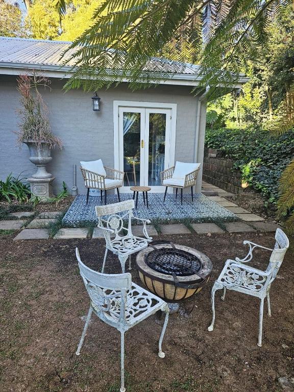 a group of chairs and a fire pit in a yard at The Rose Cottage in Hilton