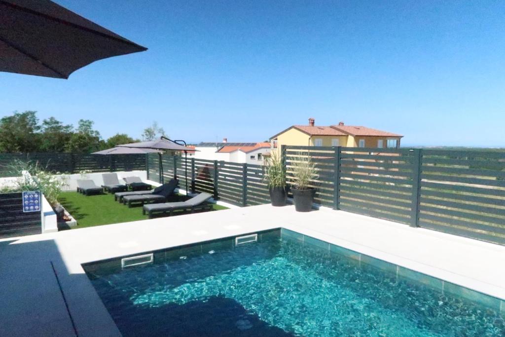 a swimming pool on top of a patio with a fence at Ferienhausanlage Adria Oasis in Višnjan