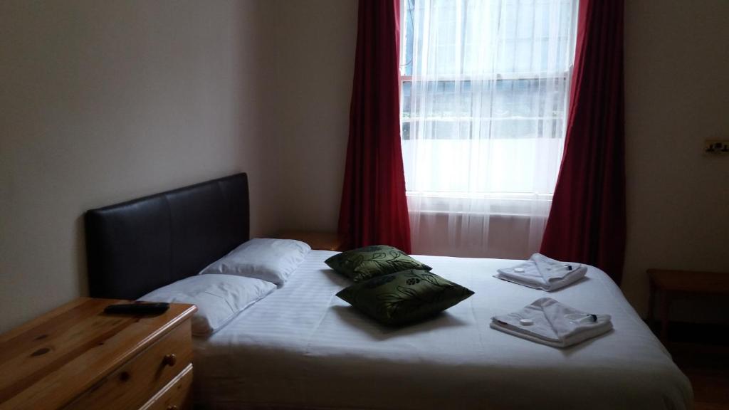 a bed with two pillows on it in front of a window at Kensington and Chelsea grand apartment in London