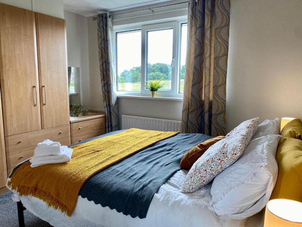 a bedroom with a bed with pillows and a window at Spacious Town Centre Apartment in Barnsley