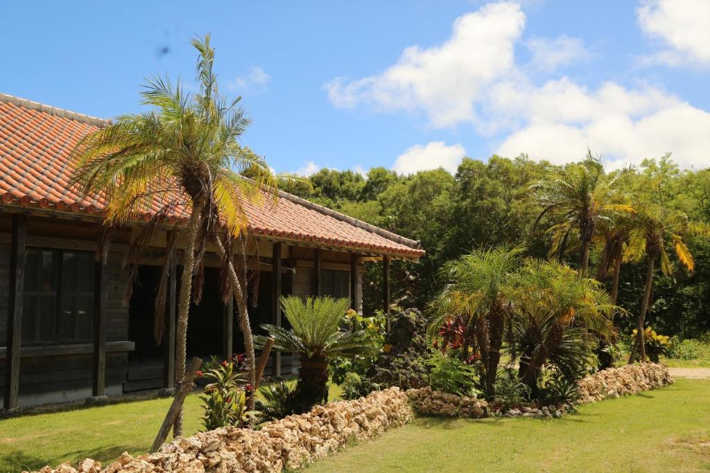 a house with palm trees in front of it at Yoga Retreat Village, kSaNa - Vacation STAY 95928v in Nagura