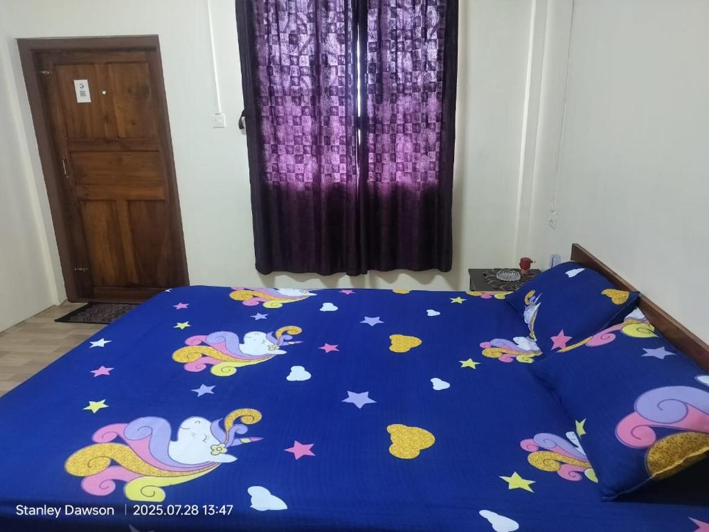 een bed met een blauw dekbed met een pokemon erop bij Ado Homestay in Shillong