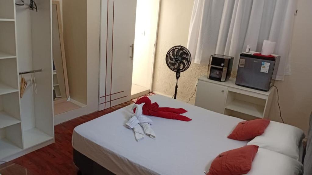 a bedroom with two beds with red pillows and a tv at Estúdio no Vieiralves in Manaus