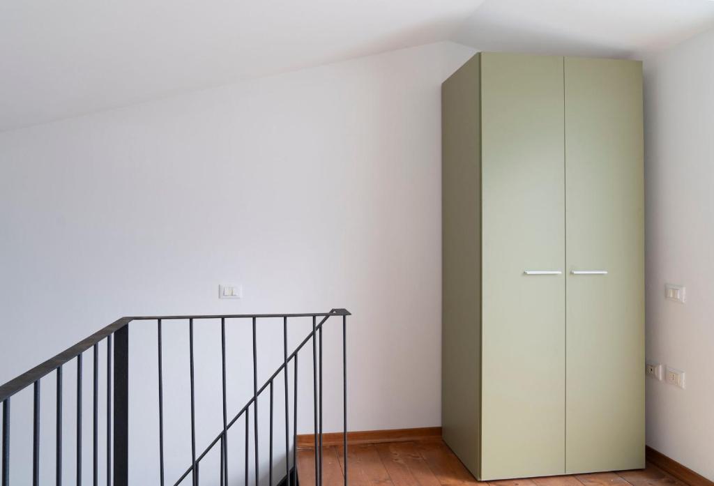 a room with a staircase and a green cabinet at L'Alzaia in Chioma