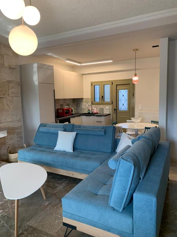 a living room with a blue couch and a kitchen at Blue Olive House & Studio in Artemida