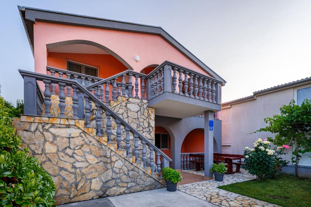 a house with a staircase and a stone wall at Apartment Vir Croatia in Vir