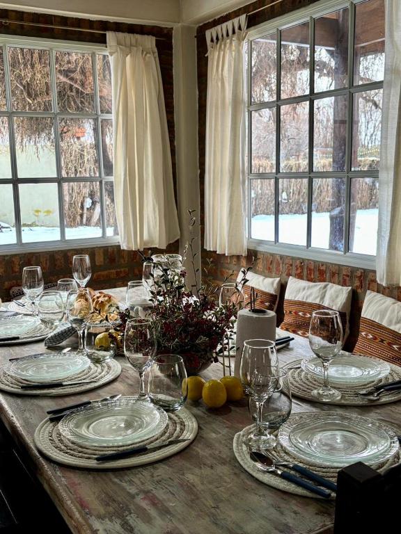 a table with plates and wine glasses on it at Casa de Mimbres in El Calafate