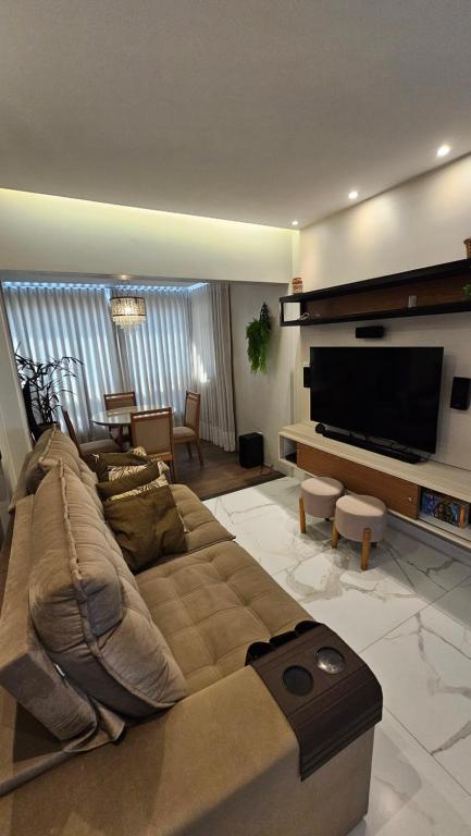 a living room with a couch and a flat screen tv at Quarto no apartamento do Edifício Ilha de Maui in Belém