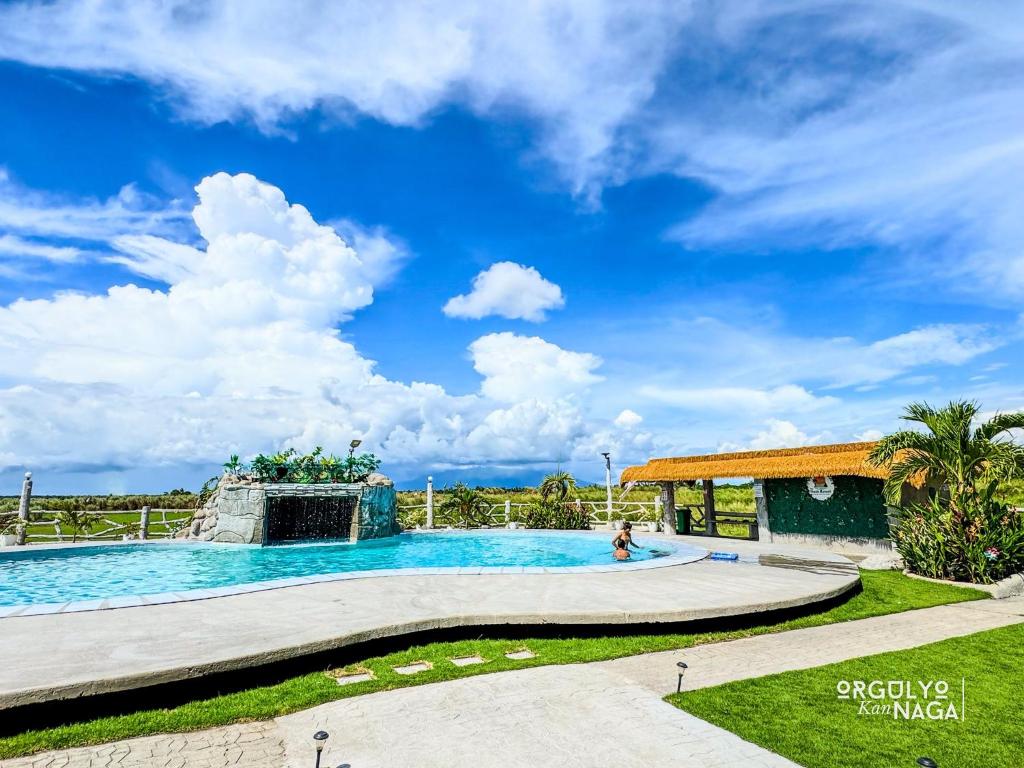 a pool at a resort with a blue sky at THE OASIS RESORT CondoBimbo 1-Big Room, Balcony, kitchen, Pool, Wifi, Videoke in San Fernando