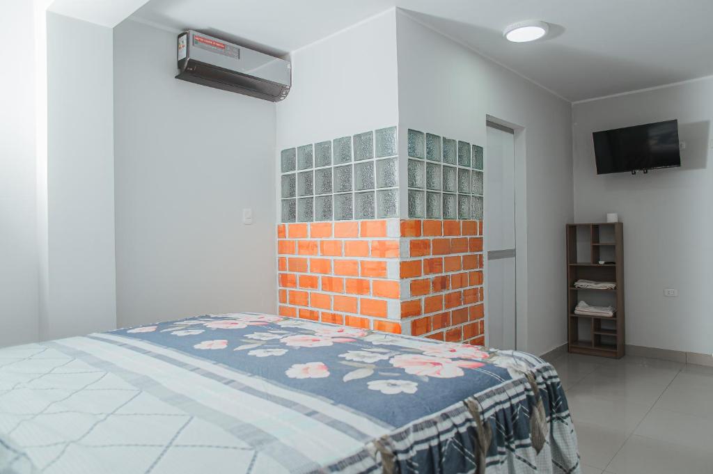 a bedroom with a brick wall and a bed at Casa Zoilita in Pucallpa