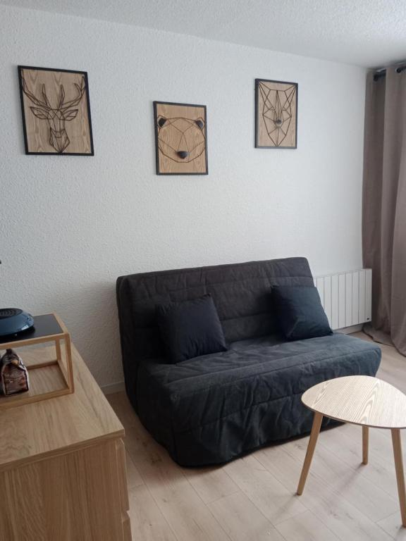 a living room with a couch and four pictures on the wall at Les Ours Bruns in Aragnouet
