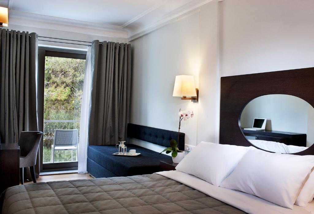 a hotel room with a bed and a mirror at Acropolis Hill Hotel in Athens